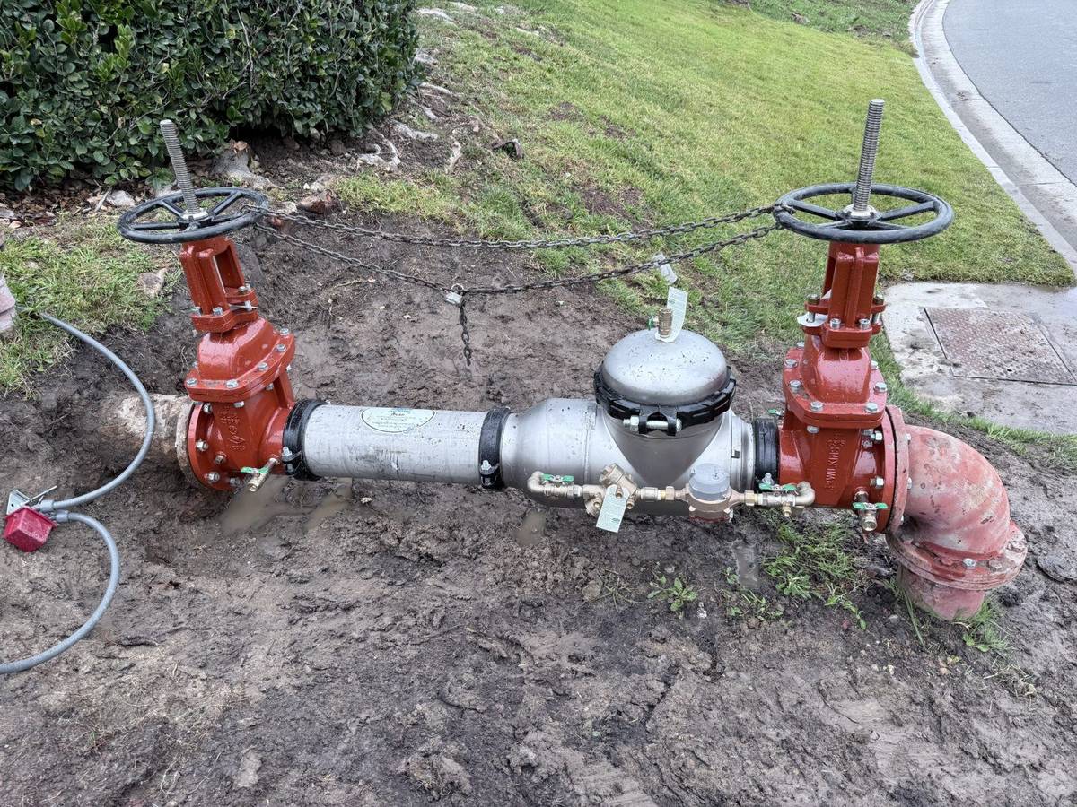 Certified backflow assembly testing in progress on a commercial property