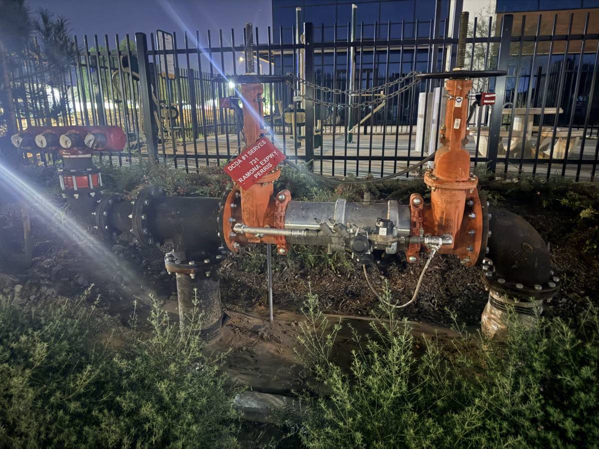 Certified backflow assembly testing in progress on a commercial property